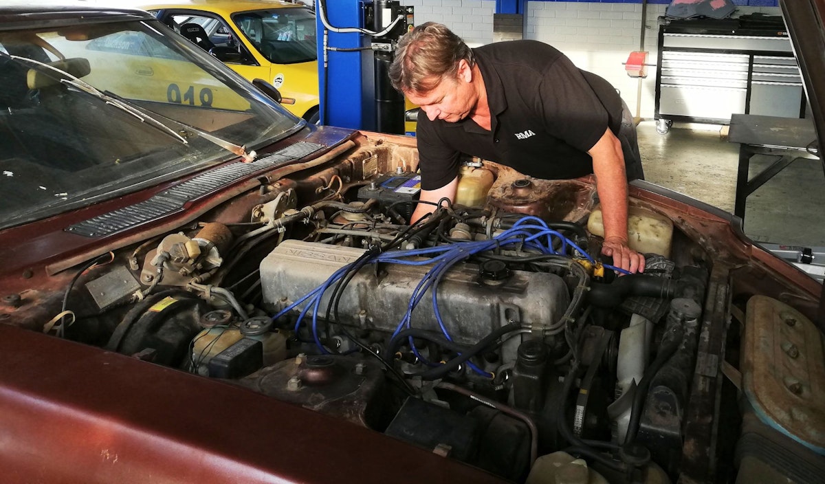 Mechanic servicing an older engine at RMA Round Men Automotive